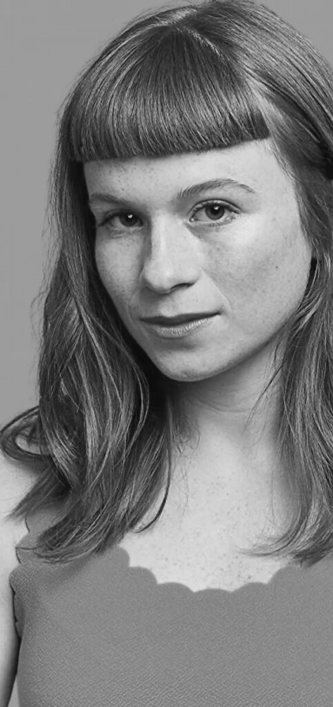 A black and white photo of a woman with bangs.